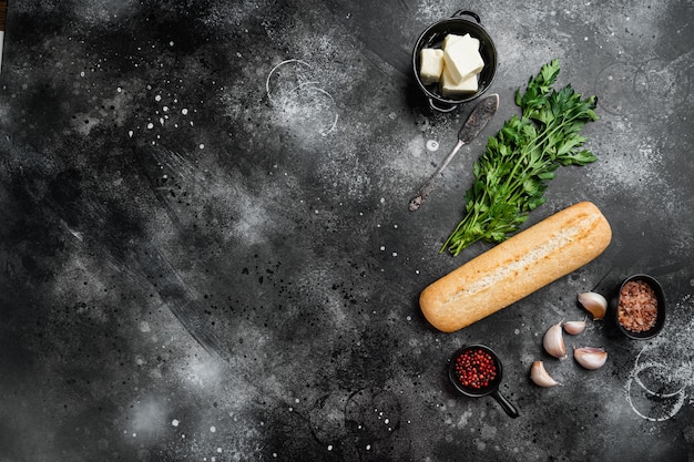 Garlic bread compound butter and herb ingredients set, on black dark stone table background, top view flat lay, with copy space for text