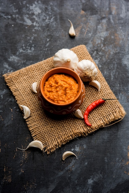 Garlic chutney, made using lahsun or lehsun originating from the India, served in a bowl over moody background. selective focus