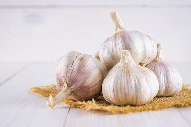 Garlic cloves and garlic bulb on a white wooden table