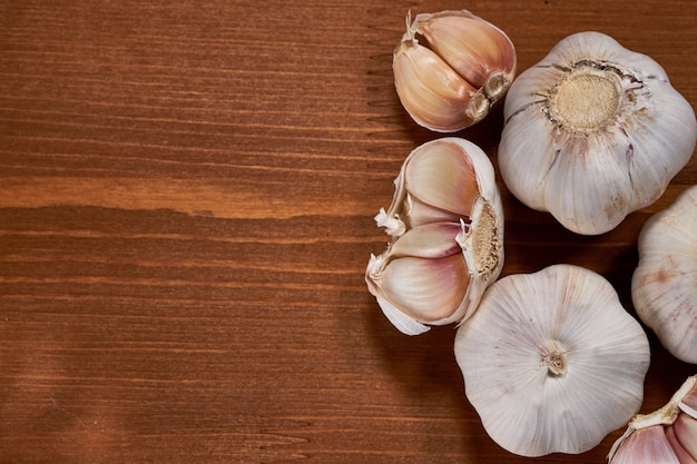 Garlic and garlic cloves on wooden background.