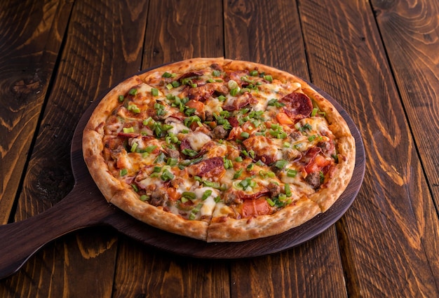 Garlic Surpreme pizza isolated on cutting board top view on dark background italian fast food