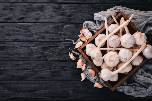 Garlic in a wooden basket Fresh garlic on a wooden background Top view Free space for text