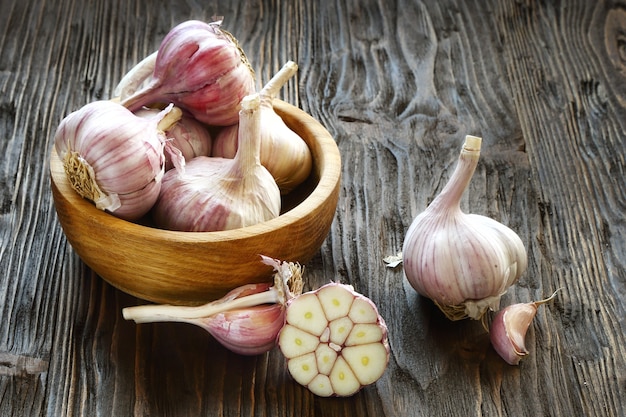 Garlic in a wooden bowl on the kitchen table