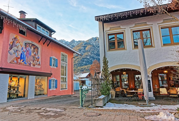 Garmisch-Partenkirchen, Germany - January 6, 2015:  Chalets with paintings in Bavarian style decorated for Christmas, Garmisch Partenkirchen old town, Germany. People on the background