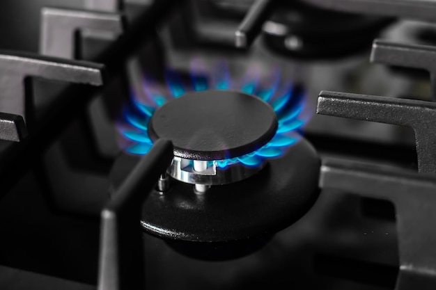 The gas burner of the black stove burns with a blue flame Production and use of fossil fuels