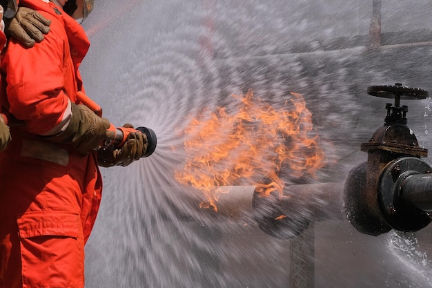 Gas leak from pipe and valvflame from gas leakfire fighting with extingguishers and fire hosefighters in action at gas Fire