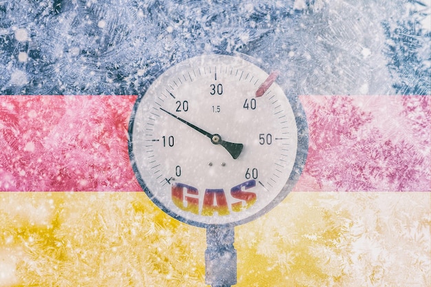 Gas pressure gauge on background of frozen flag of Germany