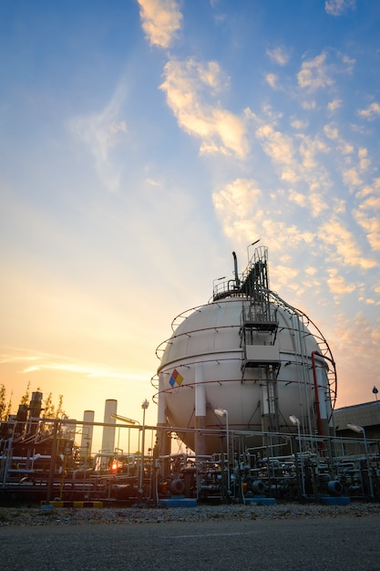 Gas storage sphere tanks in oil and gas refinery industrial plant with sunset sky