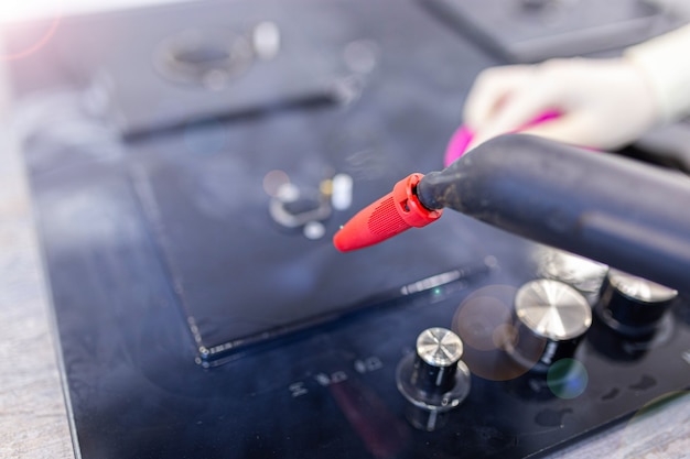 gas stove cleaning with a steam cleaner in the kitchen disinfection when cleaning the house