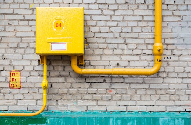 Gas supply pipes with dashboard against brick wall