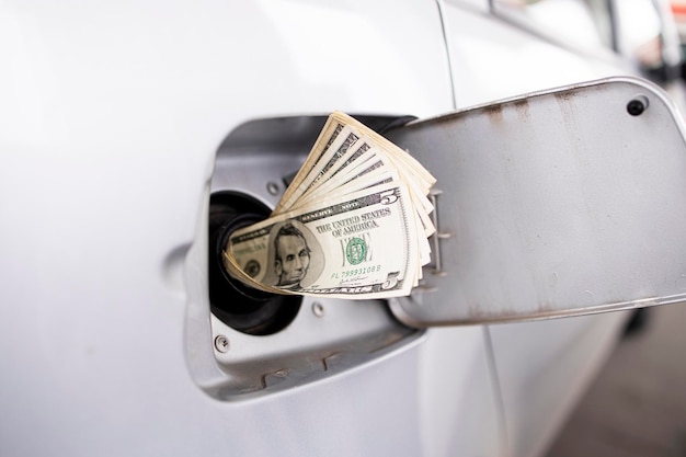 Gasoline price crisis concept and dollars in gas tank