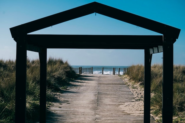 Gate to the beach with sea waves in background on sunny day