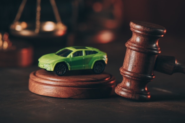 Gavel with a car model on a wooden table