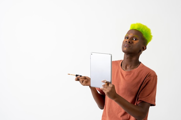 A gay black ethnic man putting on makeup LGTBI concept portrait correcting dark circles with a mirror