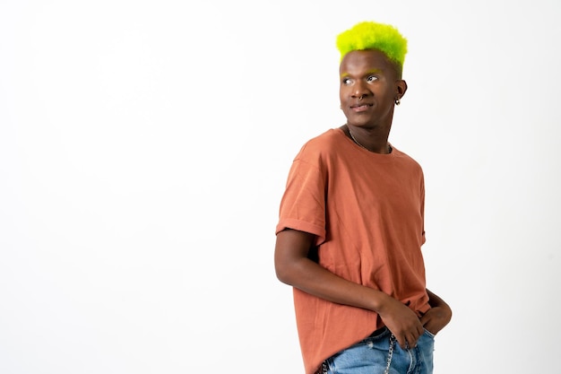 A gay black ethnicity man in studio with white background LGTBI concept modern green hairstyle