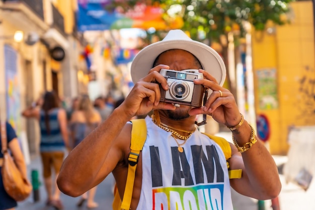 A gay black man at the pride party taking photos LGBT flag