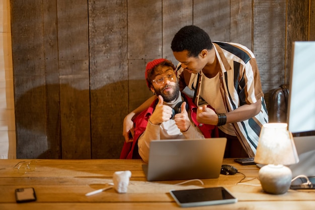 Gay couple working on computers at home office