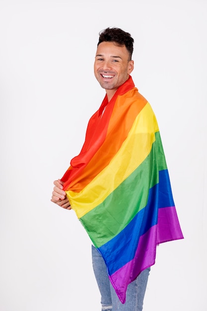 Gay man smiling with pride flag over his shoulders