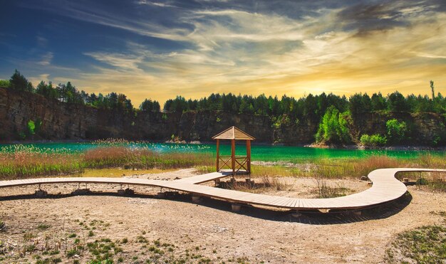 Photo gazebo by lake against sky during sunset