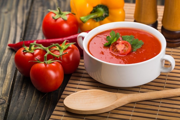 Gazpacho and ingredients on a table, vegetable soup