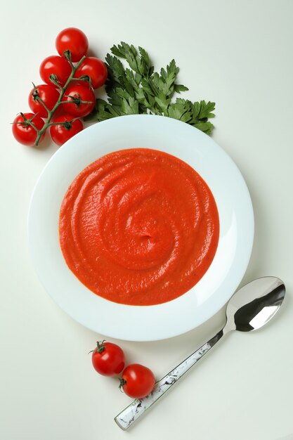 Gazpacho soup and ingredients on white background