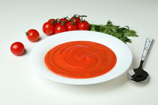 Gazpacho soup and ingredients on white background