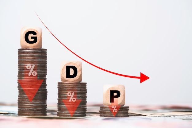 GDP or Gross Domestic Product wording on decreasing coins stacking and red down arrow for economic recession concept