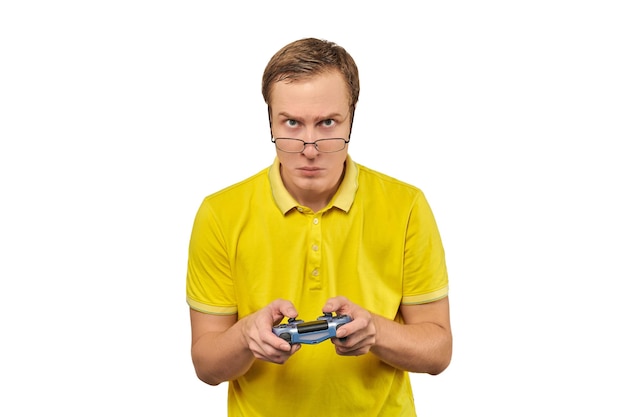 Geek gamer in glasses and yellow Tshirt with gamepad excited video game player isolated on white