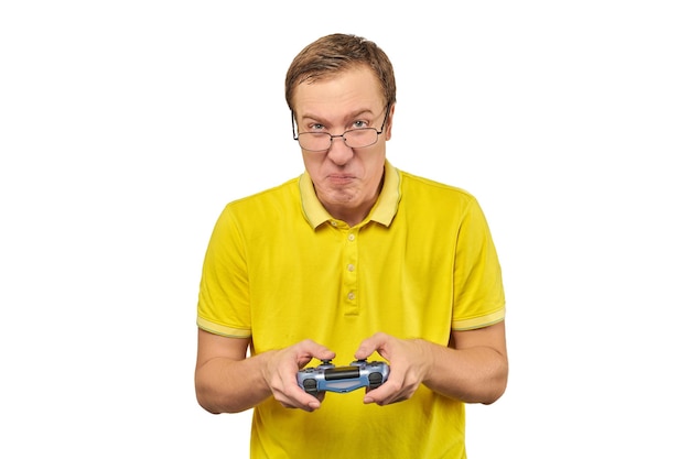 Geek gamer in glasses and yellow Tshirt with gamepad excited video game player isolated on white