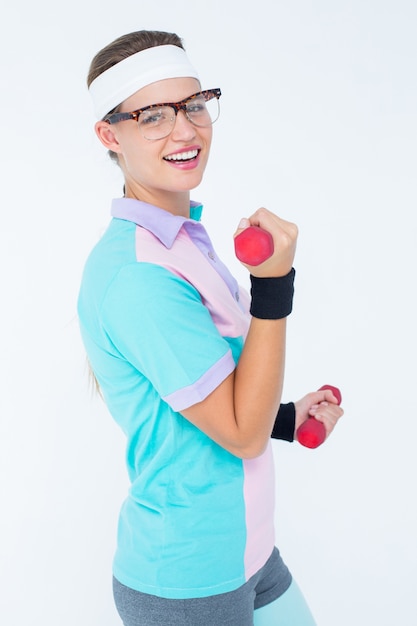 Geeky hipster girl lifting dumbbells 