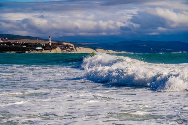 Gelendzhik lighthouse in a storm on the Black sea Splashes waves rocks and mountains