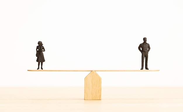 Gender equality concept Man and woman figurine on a seesaw Copy space