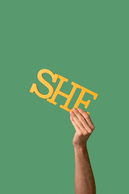 Gender fluid person holding a pronoun isolated on green