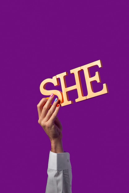 Gender fluid person holding a pronoun isolated on purple