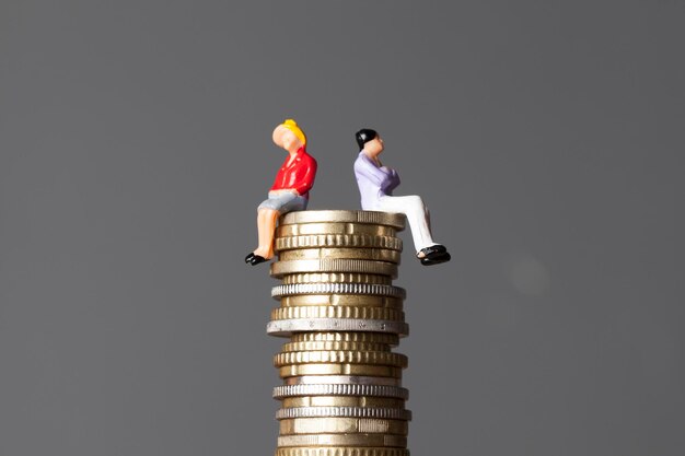 Photo gender pay equality concept man and woman on a stack of coins