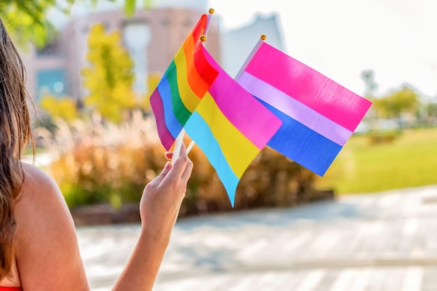 Gender queer Female hand hold lgbtq bisexual and pan sexual flag Selective focus