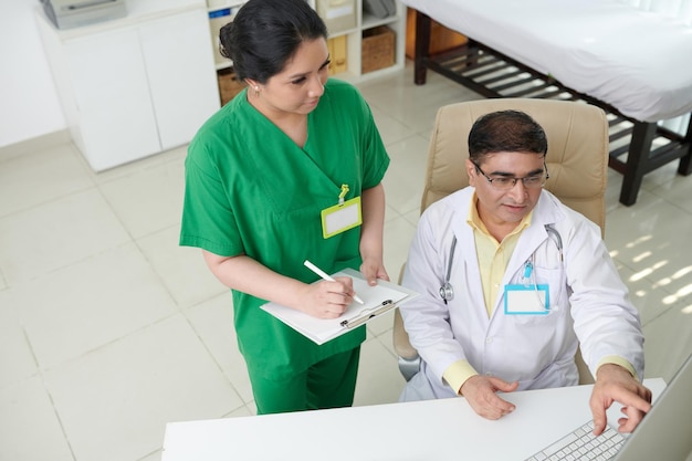 General practitioner discussing results of medical tests of patient with nurse