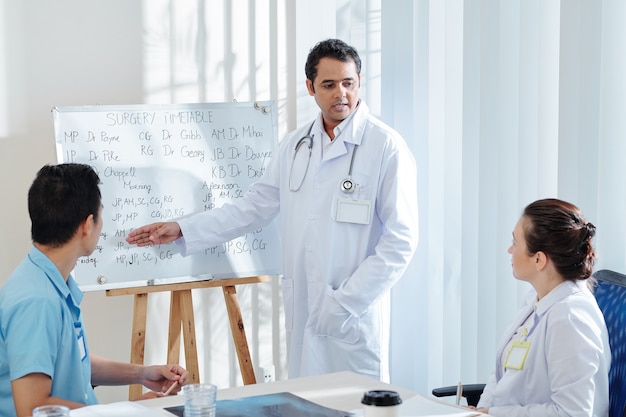 General practitioner showing surgery timetable