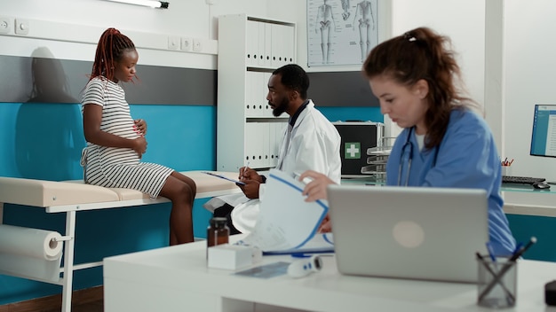 General practitioner taking notes on documents at appointment