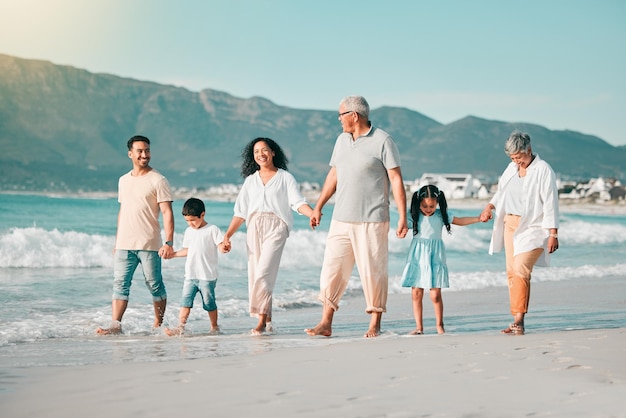 Generations holding hands and walking family on beach and ocean waves freedom and bonding in nature Grandparents parents and kids people outdoor and travel with trust and love on Mexican holiday