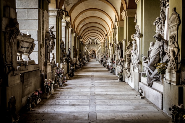 GENOA, ITALY - June 2020: corridor with statues - beginning 1800 - in a Christian Catholic cemetery - Italy