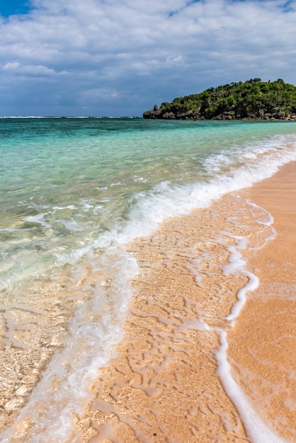 Gentle crystalline wave breaking over the sands along the shore white foam