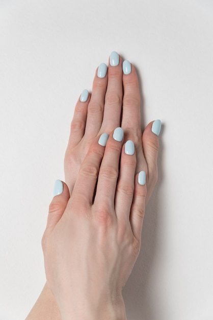 Gentle summer manicure, gel Polish. Female hands on white . Verrical frame.