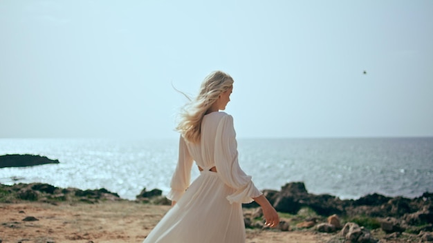 Gentle woman relaxing coast at beautiful sunset light girl walking ocean shore