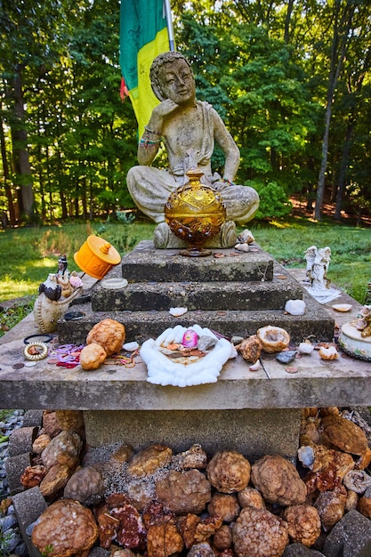 Geodes donated to small stone Tibetan Mongolian Buddhist statue in forest