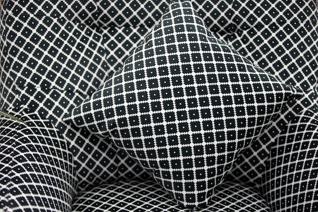 Photo geometric pattern with black and white rhombuses on the pillow and chair