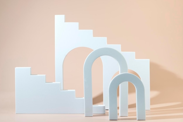 Geometric shapes stairs podiums and archs standing on a beige background