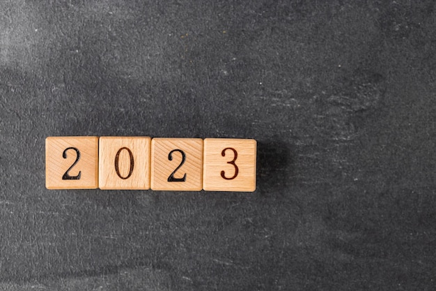 Geometric wood cubes on table with numbers 2023 Concept of new year 2023 copy space