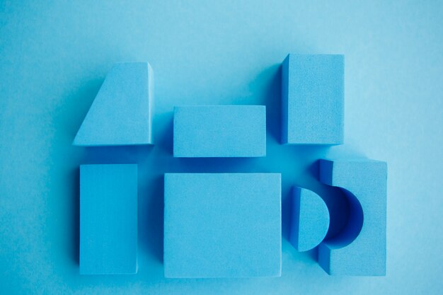 Geometrical figures still life composition. Cube and other objects on blue background. 