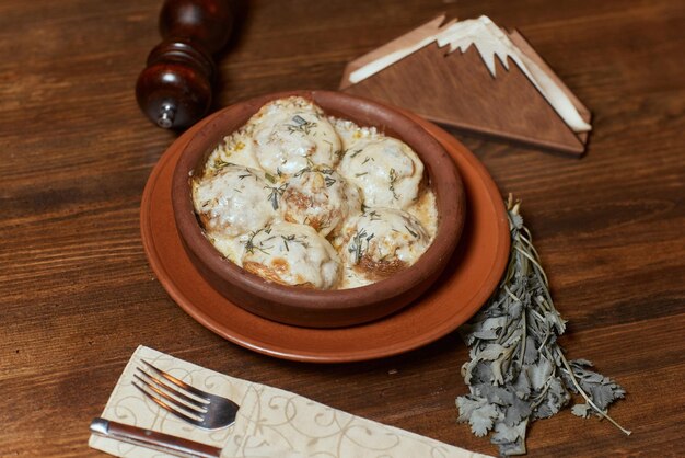 Georgian cuisine Baked mushrooms champignons with meat cheese parsley and pomegranate Serving in a restaurant in an iron pan background image copy space